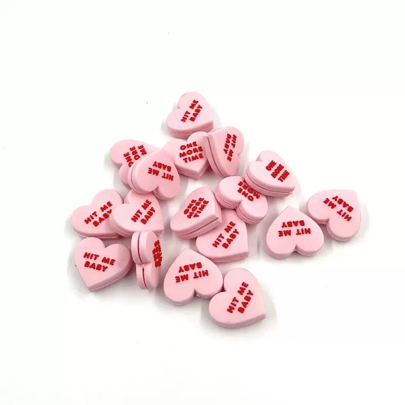 Pink custom-shaped tennis dampeners with short printed text
