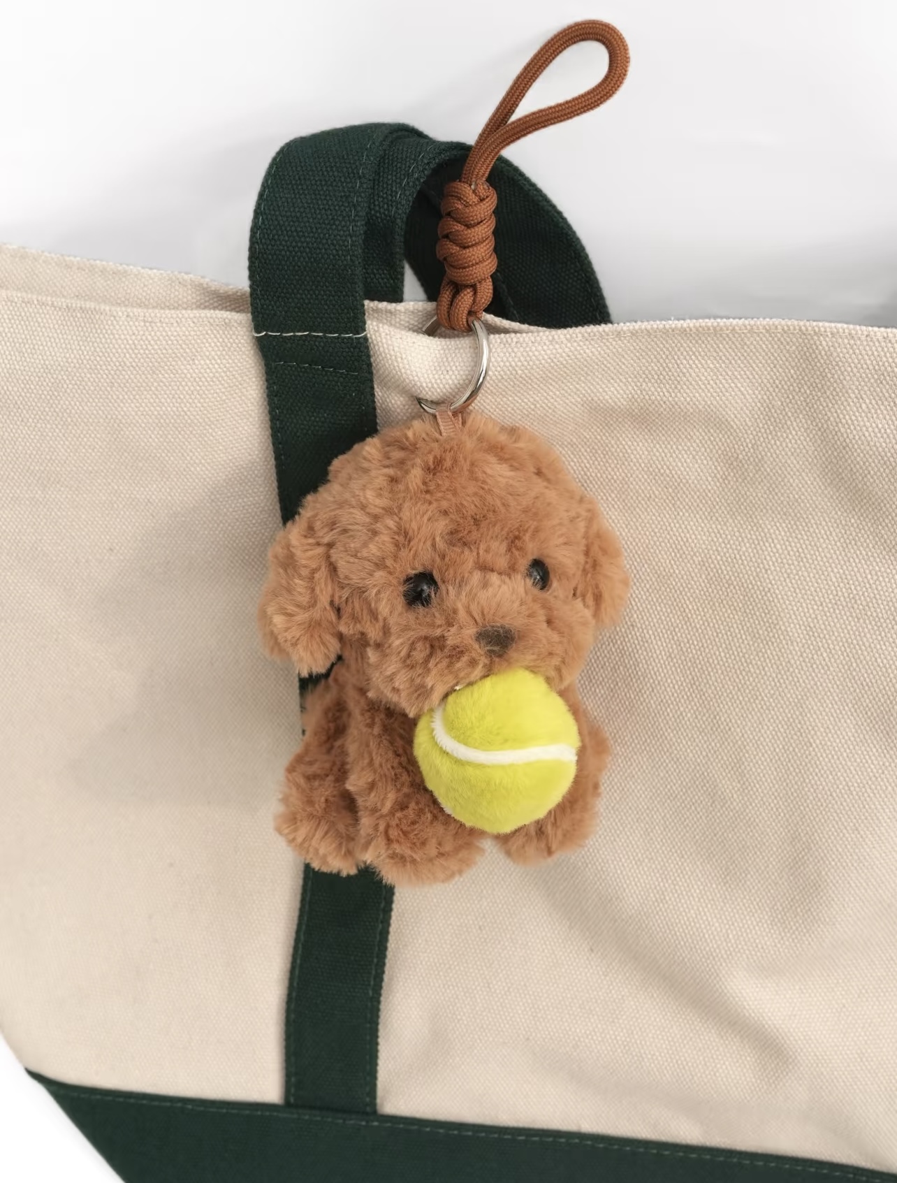 Tennis-themed plush bag charm attached to a tote