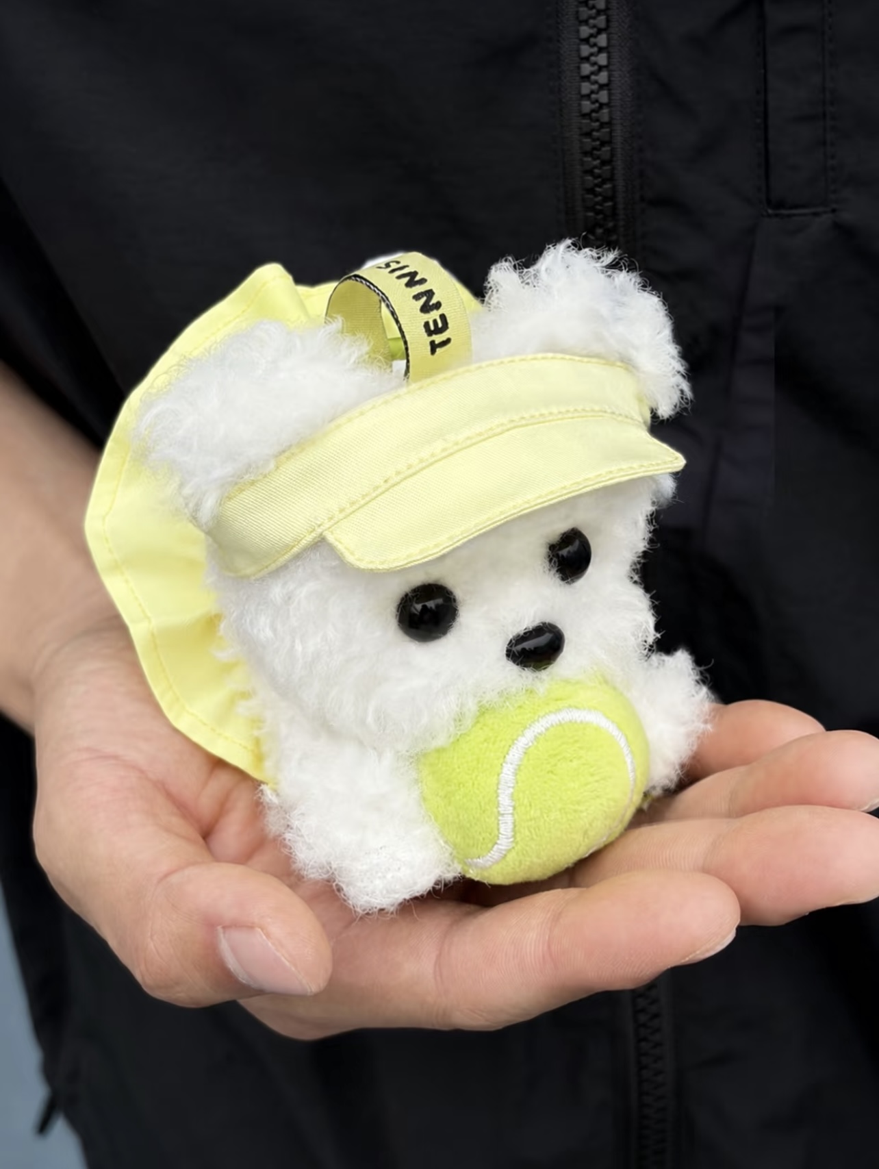 Tennis-themed plush dog charm with a visor