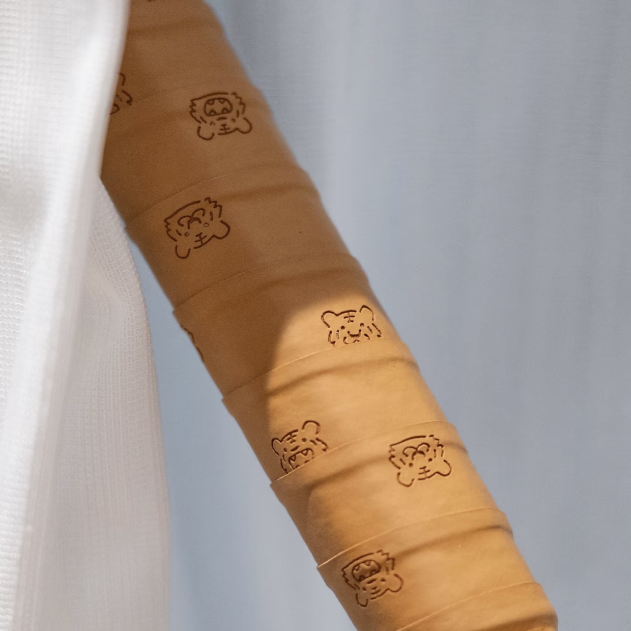 Brown overgrip with a subtle embossed repeat pattern