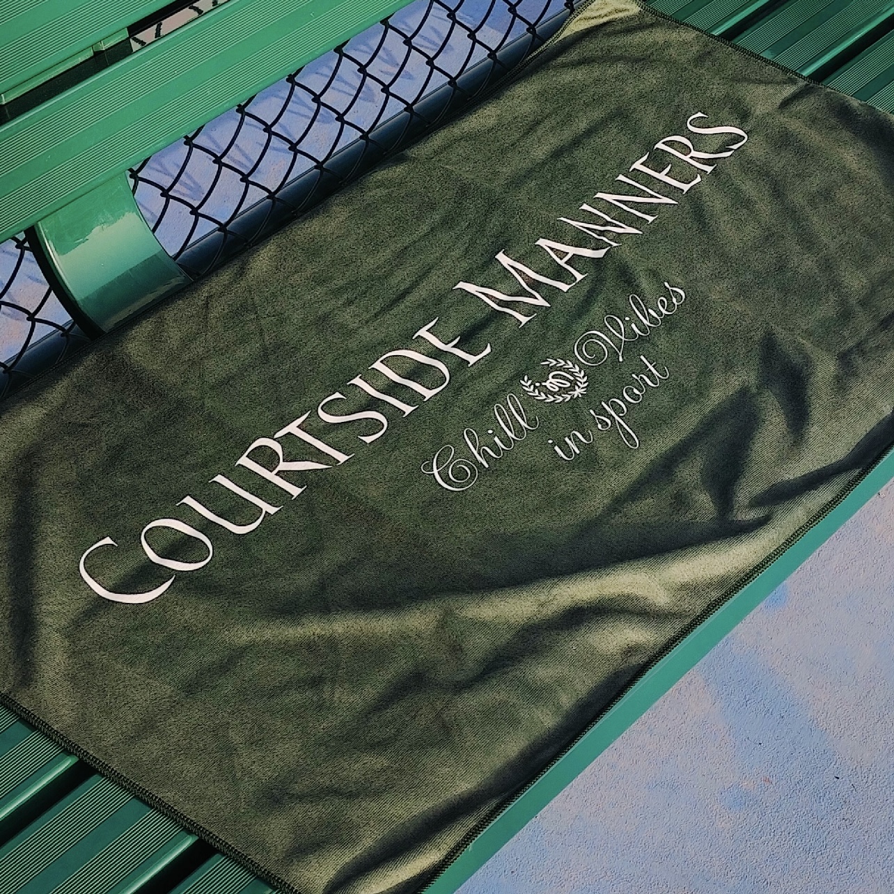 Dark green court towel with large club-style text branding