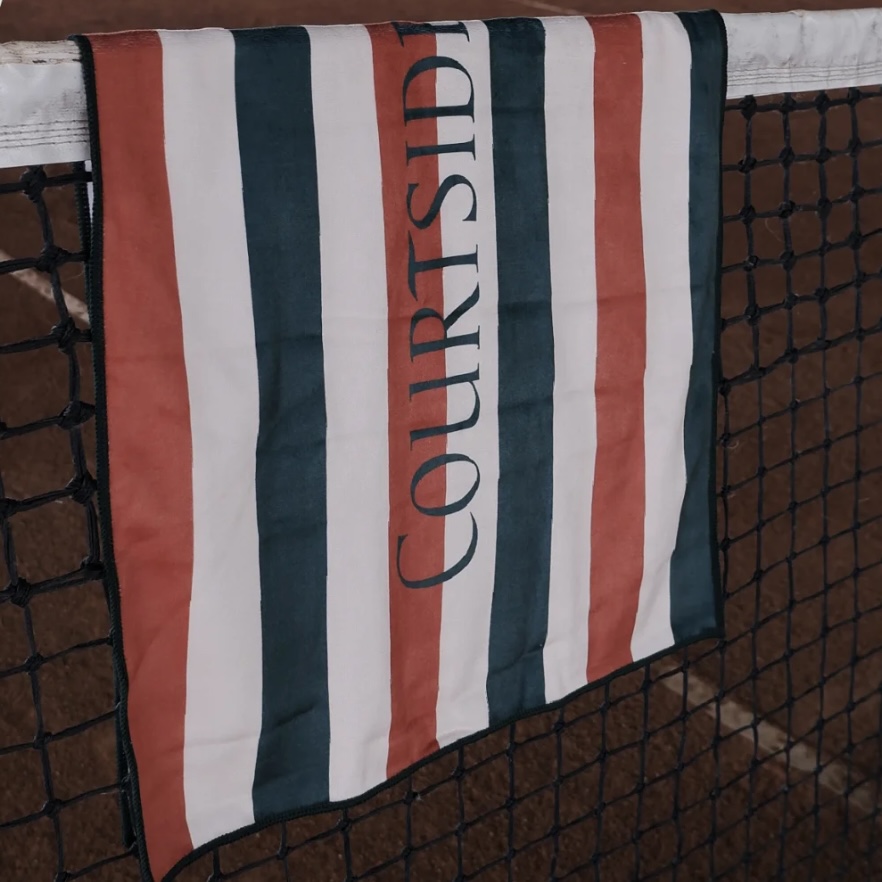 Striped full-print court towel displayed on a tennis net