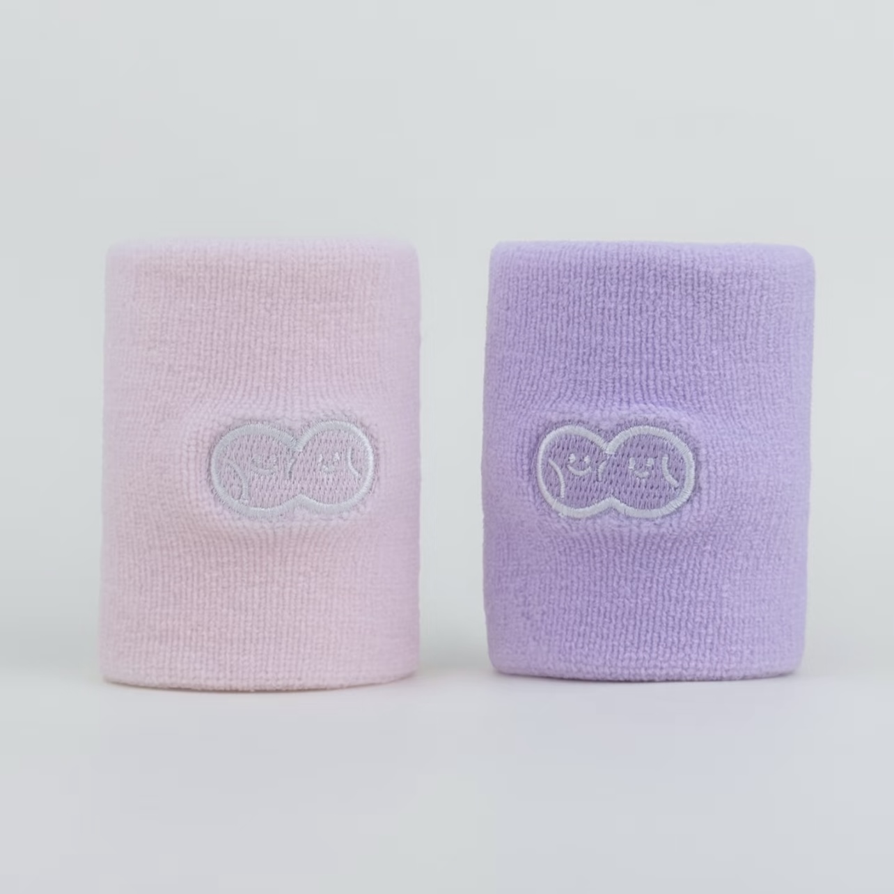 Pastel pink and lavender wristbands with subtle embroidered symbols